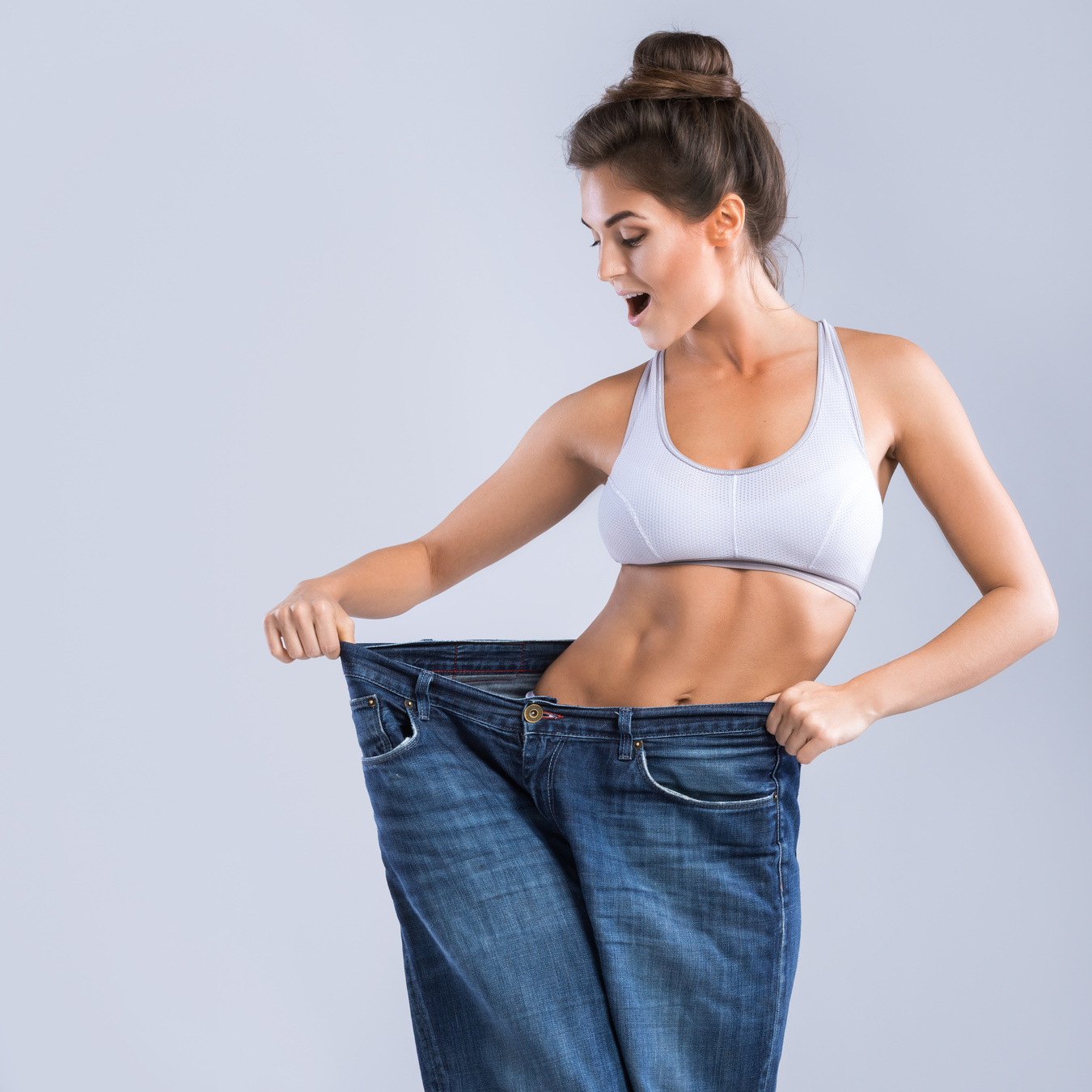 Fit Woman Wearing Loose Jeans on White Background